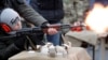 An officer of Belarus's Interior Ministry teaches a child to fire an automatic weapons in March 2020