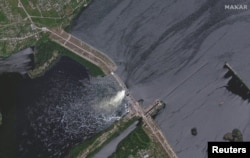 На спутниковом снимке видна дамба Каховской ГЭС в Херсонской области до подрыва ее российскими войсками, 28 мая 2023 года. Maxar Technologies/Handou