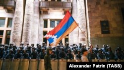 Armenia -- A protester waves the Karabakh flag as riot police officers guard the Armenian government building in Yerevan, September 2, 2023.