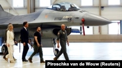 Президент Украины Владимир Зеленский и глава НАТО Марк Рютте, бывший премьер-министр Нидерландов, идут на фоне самолета F-16 в Эйндховене, Нидерланды, 20 августа 2023 года