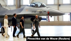 Președintele ucrainean, Volodimir Zelenski, inspectează un avion F-16 alături de fostul premier olandez, Mark Rutte, la baza aeriană din Eindhoven, Olanda, 20 august 2023.