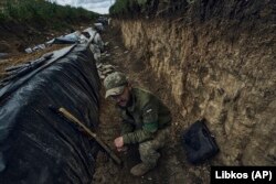 Un soldat ucrainean stă într-un șanț săpat pe linia frontului în apropiere de Bahmut, în regiunea Donețk, Ucraina, 22 mai 2023.