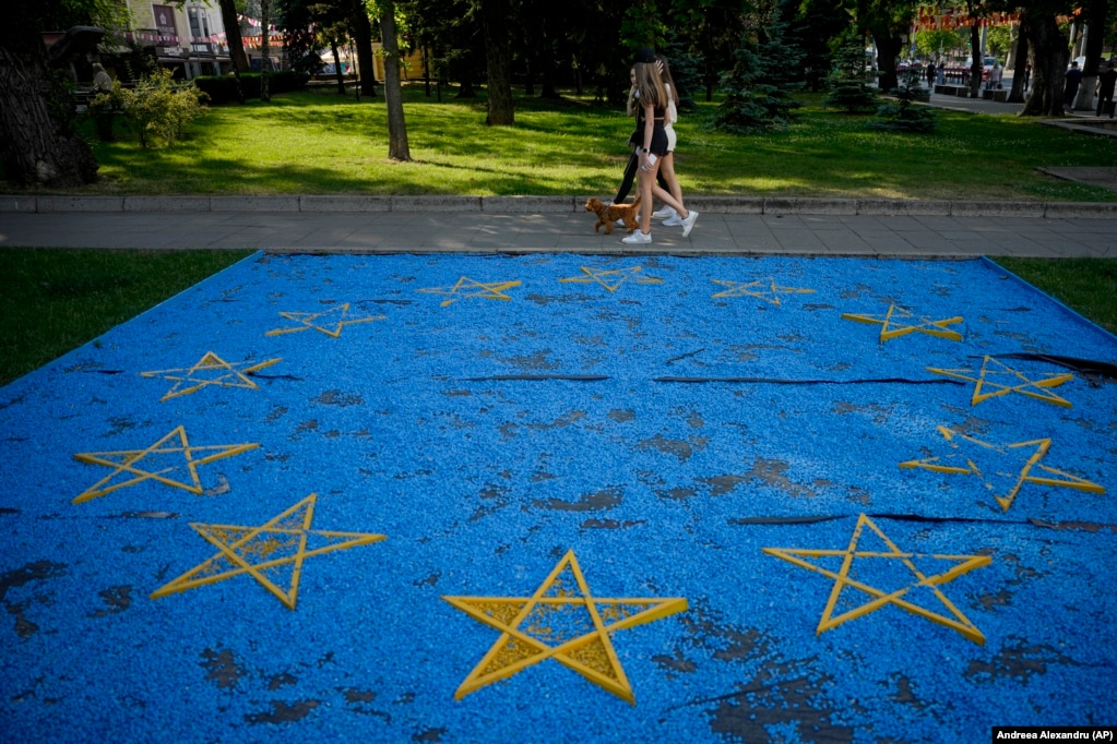 Disa vajza duke kaluar pranë një instalacioni me flamurin e BE-së në një park në Kishinau përpara një samiti të liderëve evropianë në kryeqytetin moldav.