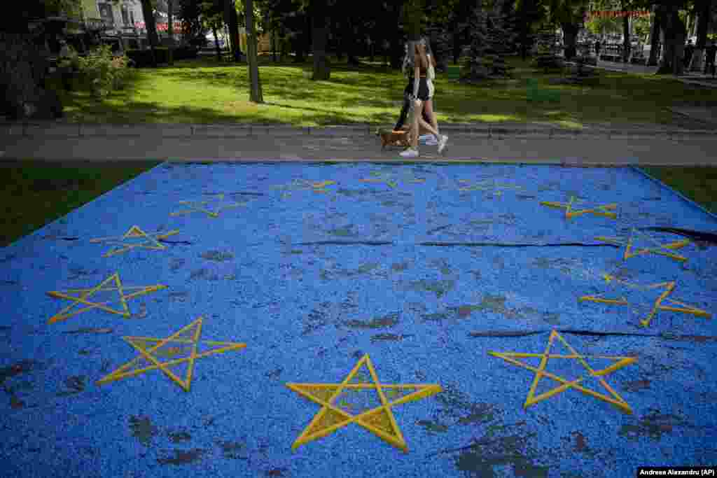 Devojke prolaze pored postavljene zastave EU u parku u Kišinjevu uoči samita evropskih lidera u glavnom gradu Moldavije