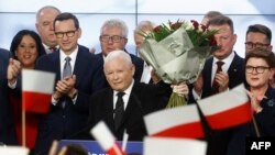 Jaroslaw Kaczynski (centru) și premierul polonez Mateusz Morawiecki (al treilea de la stânga), la sediul partidului Lege și Justiție, după prezentarea rezultatelor sondajului la ieșirea de la urne.