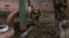 A man inspects part of a missile that fell next to a residential building that was damaged during an overnight Russian attack in the southern city of Kherson on October 30.