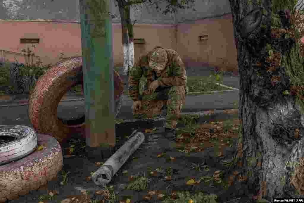 A man in a military uniform looks at part of a missile next to a residential building that was damaged during an overnight Russian attack on October 30. Doctors Without Borders (MSF) was forced to evacuate 150 patients from a hospital in Kherson due to ongoing shelling. This was the second time MSF has had to evacuate patients from the same hospital in the past year as a result of attacks on the facility.