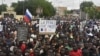 پلاکارد حاوی شعار ضد فرانسه در دست حامیان کودتای نیجر در تظاهرات روز سوم اوت که در نیامی برگزار شد