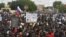 پلاکارد حاوی شعار ضد فرانسه در دست حامیان کودتای نیجر در تظاهرات روز سوم اوت که در نیامی برگزار شد