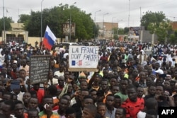 Protestatarii țin o pancartă anti-Franța în timpul unei demonstrații de ziua independenței la Niamey, pe 3 august 2023.