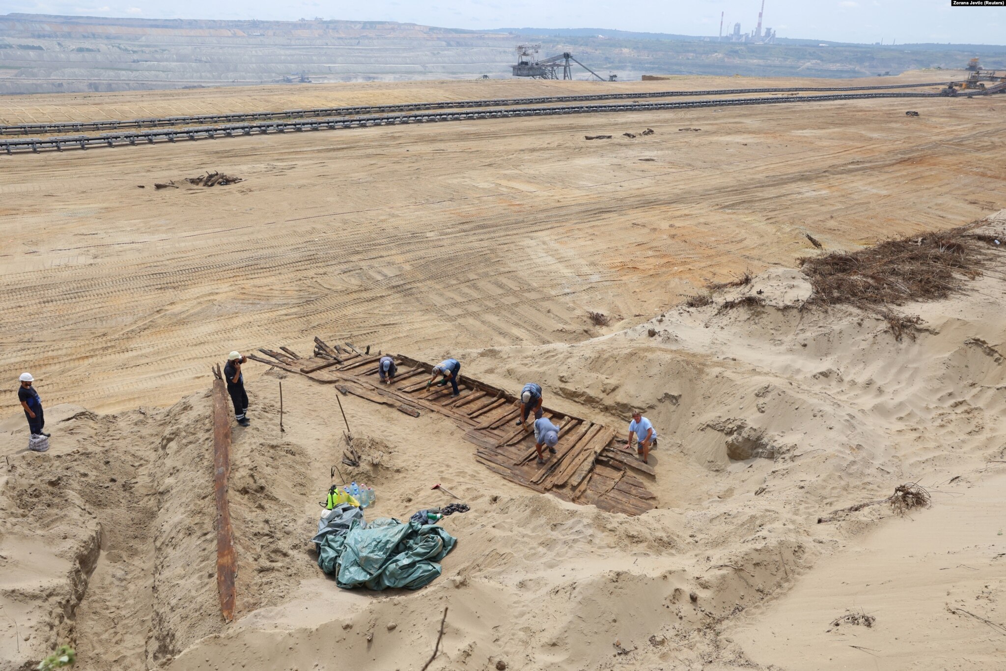 Archaeologists near Kostalac, Serbia, painstakingly brush sand and soil off the woodwork of an ancient Roman ship on August 2. The ship was discovered by an excavator crew at the Drmno mine.