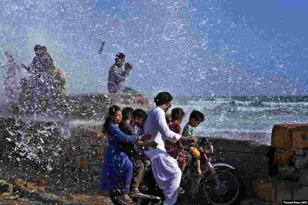 People enjoy high-tide waves on the Arabian Sea in Karachi, Pakistan.