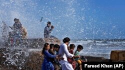 PAKISTAN -- People enjoy high tide waves on the Arabian Sea in Karachi, Pakistan, Sunday, June 11, 2023. 