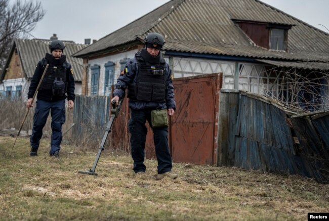 Sappers inspect an area for mines and unexploded shells in Kharkiv region.