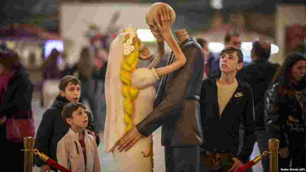 Ljudi gledaju par kostura koji se ljube u sklopu instalacije pod nazivom &quot;Dok nas smrt ne rastavi&quot; tokom događaja za Dan zaljubljenih u Bukureštu.