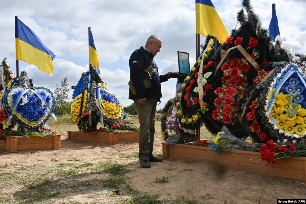 Një banor i Iziumit, në lindje të Ukrainës, e viziton Shtegun e Lavdisë në varrezën e qytetit, në shtator 2023.
