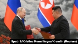 Presidenti rus, Vladimir Putin, shtrëngon duart me udhëheqësin verikorean, Kim Jong Un, gjatë ceremonisë së nënshkrimit të paktit për mbrojtje. Phenian, 19 qershor 2024. 