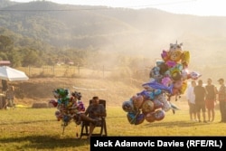 Un vânzător de baloane pentru copii este învăluit în fumul festivalului de gătit.