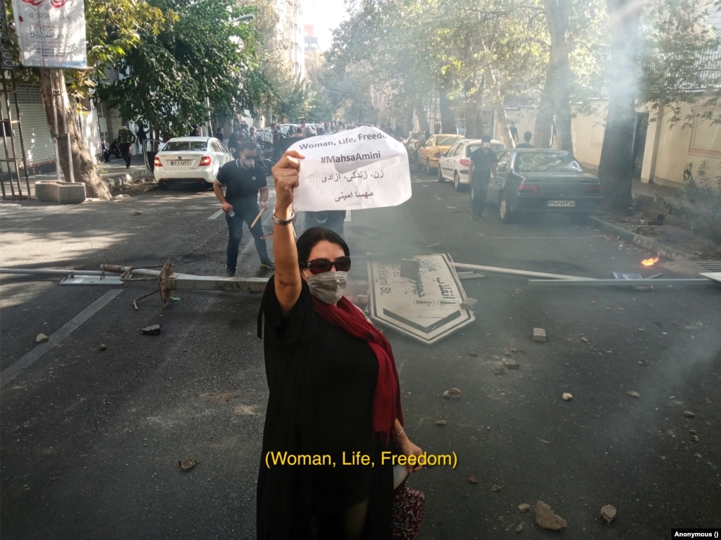 Kjo fotografi shpërfaq rreziqet me të cilat janë përballur protestuesit në rrugët e Iranit. Protestat kanë nisur në shtator të vitit 2022, pasi Mahsa Amini, 22-vjeçare, ka vdekur sa ka qenë në mbajtje policore. Ajo është ndalur nga autoritetet, me arsyetimin se nuk e ka vendosur si duhet shaminë në kokë. Fotografi me autor anonim.