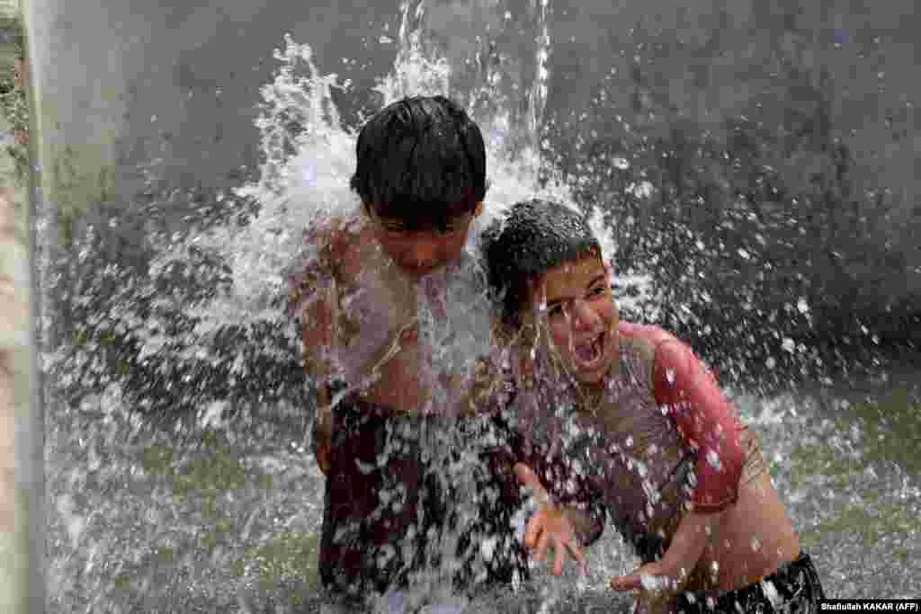 Boys play under a water tap in Jalalabad, Afghanistan.