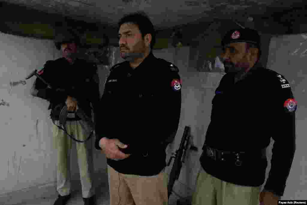 Assistant subinspector Jameel Shah, 40, stands between two police officers as they observe their surroundings at the Sarband Police Station on the outskirts of Peshawar. This outpost, along with eight others, has suffered four major attacks in recent months. &quot;We&rsquo;ve stopped [the militants&#39;] way to Peshawar,&quot; Shah said.