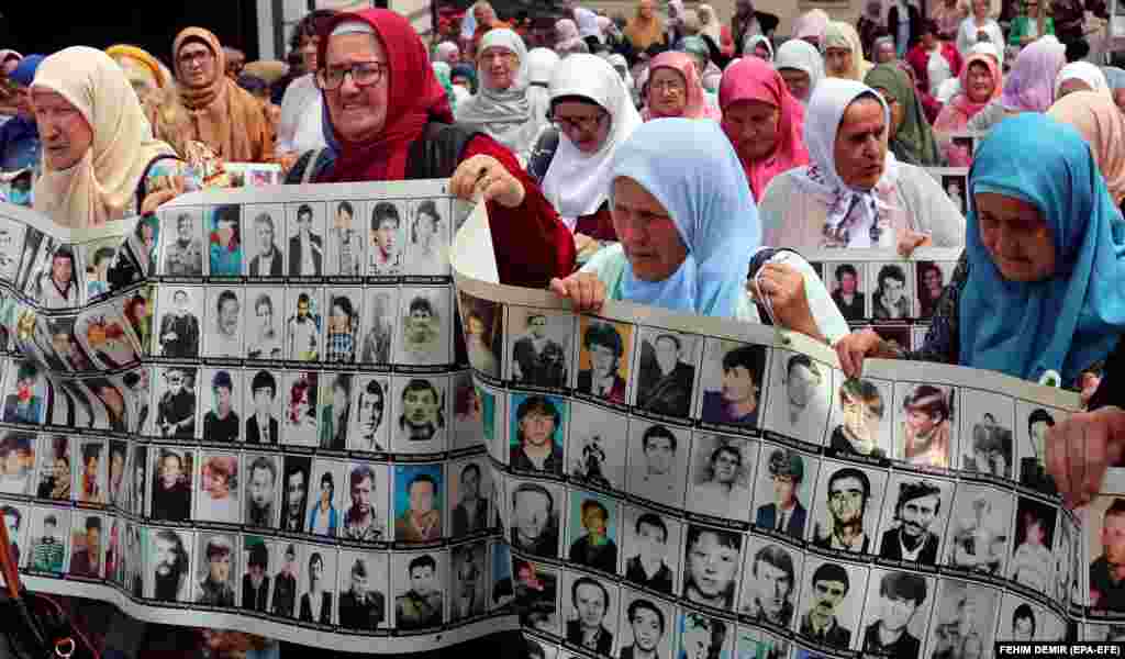 Women from Srebrenica hold banners showing pictures of victims of the 1995 Srebrenica massacre at a demonstration in Zenica, Bosnia-Herzegovina, on June 11.