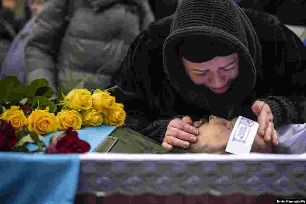 Roza duke qarë mbi trupin e burrit të saj, Oleksandr Maksymenko, 38 vjeç, gjatë funeralit të tij në fshatin e tij të lindjes Kniazhyçi, në lindje të Kievit. Oleksandr, një civil i cili ishte vullnetar në forcat e armatosura të Ukrainës, u vra gjatë luftimeve në zonën e Bahmutit.