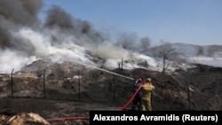 Пожарникарите гаснат пожар во централна Грција, 26 јули 2023 година. 
