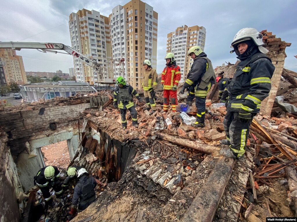 I soccorritori lavorano sul sito di un edificio residenziale a Kharkiv.  L'attacco arriva meno di 24 ore dopo un altro attacco missilistico mortale nel nord-est dell'Ucraina che ha ucciso almeno 50 persone mentre partecipavano a una veglia funebre.