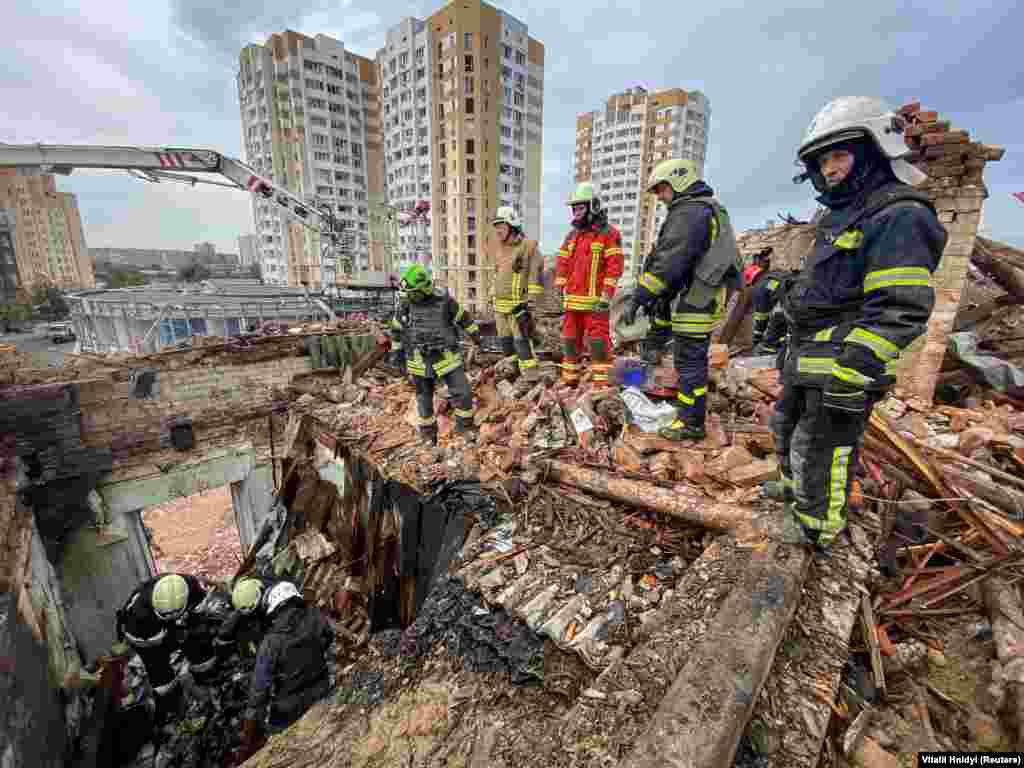 Rescuers work at the site of a residential building in Kharkiv. The attack comes less than 24 hours after another deadly missile strike in Ukraine&#39;s northeast that killed at least 50 people while they were attending a wake.