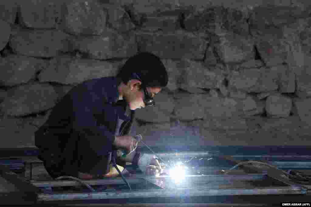 An Afghan boy welds a frame at a workshop in the Fayzabad district of Badakhshan Province.