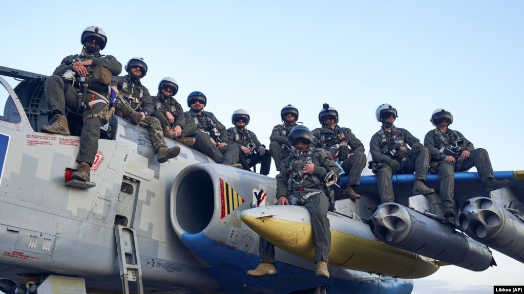Пілоти Повітряних сил ЗСУ позують для фото, сидячи на штурмовику Су-25, на своїй базі на сході України, травень 2023 року