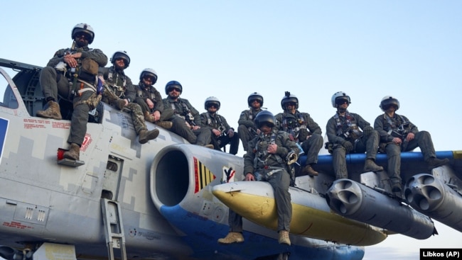 Пілоти Повітряних сил ЗСУ позують для фото, сидячи на штурмовику Су-25, на своїй базі на сході України, 4 травня 2023 року