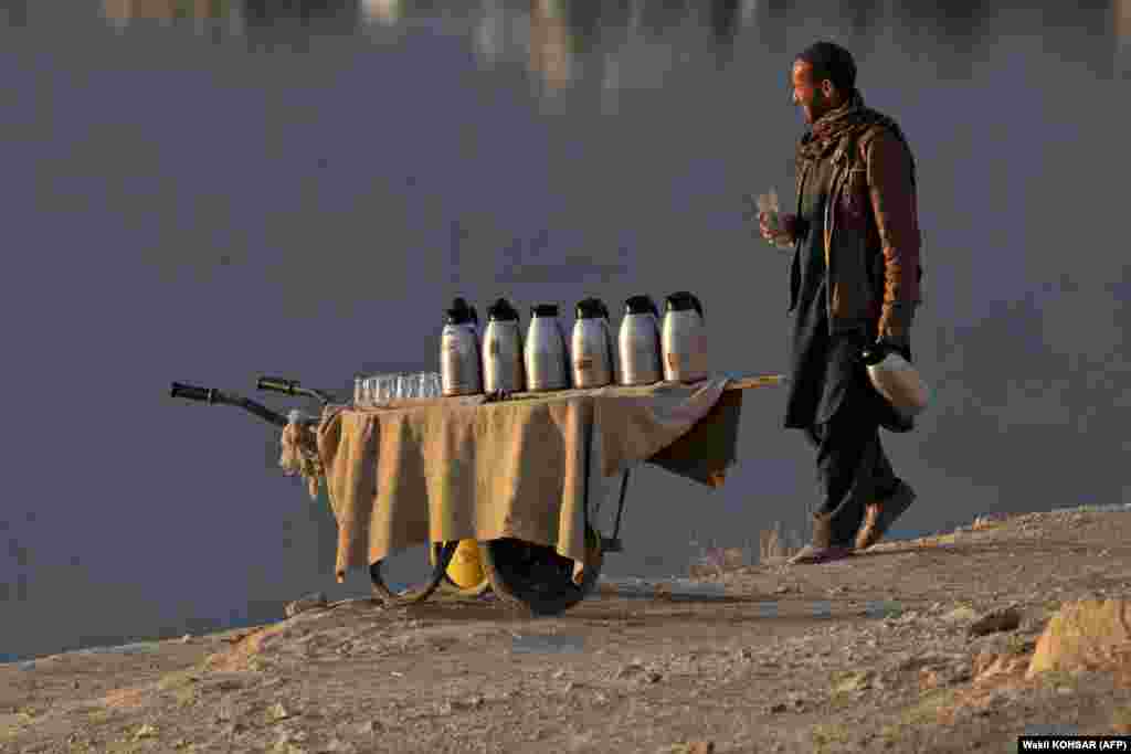 Продавец афганского чая ищет покупателей на берегу озера Карга на окраине Кабула.