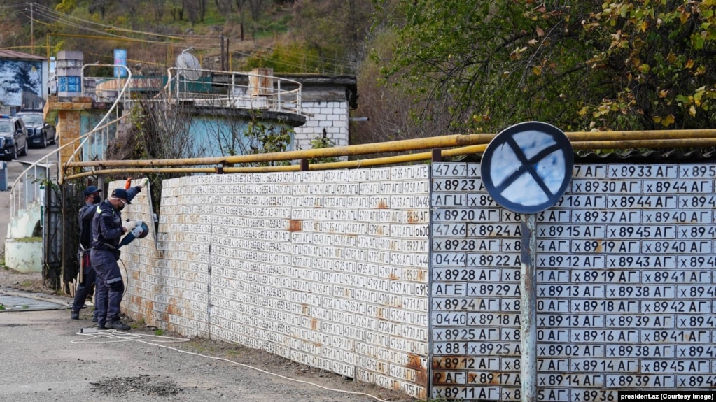 Punëtorët e presin një gardh të ndërtuar me targat e automjeteve të Azerbajxhanit që forcat armene i kishin kapur në vitet '90.