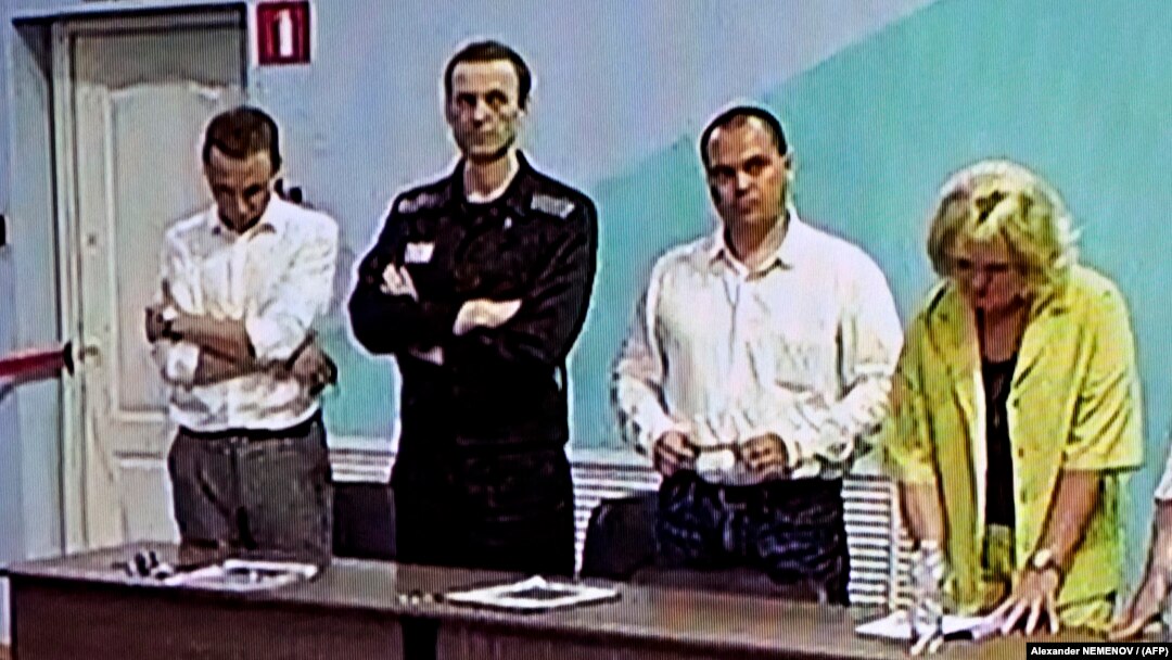 Aleksei Navalny (second from left) listens as the latest verdict against him is read out on August 4. 