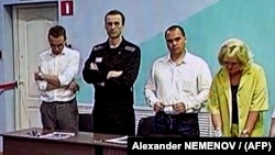 Aleksei Navalny (second from left) listens as the latest verdict against him is read out on August 4. 