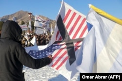 Афганцы сжигают флаг США во время акции протеста против сожжения Корана шведско-датским ультраправым политиком Расмусом Палуданом. 27 января 2023 года