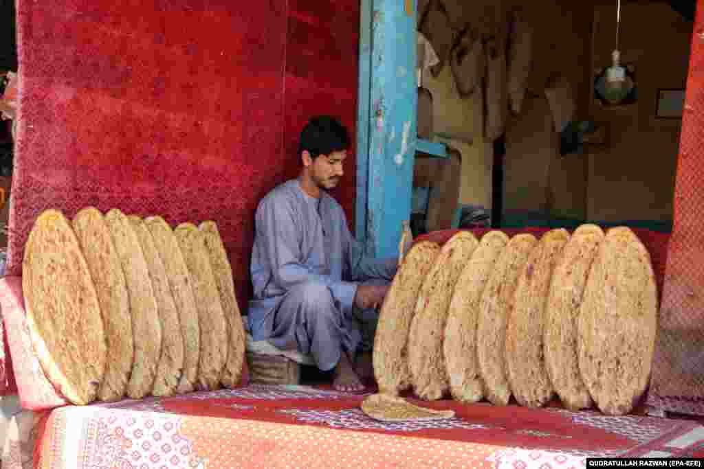 Kandahar, Afganistan, 23 aprilie. Un bărbat vinde pâine, pe stradă. Un raport recent al Băncii Mondiale arată o scădere cu 26% față de anul precdent a producției brute din Afganistan - e atribuită în principal reducerii veniturilor fermierilor cu 1,3 miliarde de dolari americani, datorită interzicerii cultivării drogurilor.