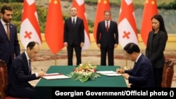 Georgian and Chinese officials ink a strategic-partnership agreement in July with Georgian Prime Minister Irakli Garibashvili (left) and his Chinese counterpart, Li Qiang, in the background.