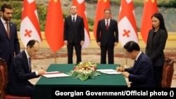 Georgian Prime Minister Irakli Garibashvili (left) inking a strategic partnership agreement in China in late July