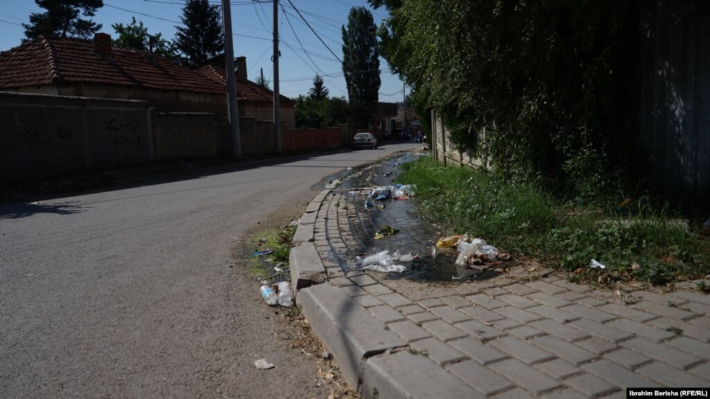 Ujërat e zeza edhe në trotuarin e rrugës në Mahallën e Romëve në Graçanicë. 19 korrik 2023.