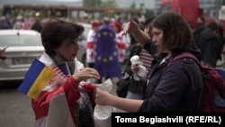 Mariam Gaprindashvili distributes faces masks and protective glasses to the protesters.