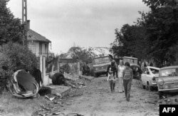 People walk among the fallen wreckage of the Tu-144 that crashed onto Goussainville.