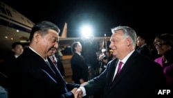 Chinese President Xi Jinping (L) is greeted by Hungarian Prime Minister Viktor Orban as he arrives Budapest.