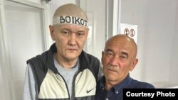 Kazakh journalist Duman Mukhammedkarim (left) and his father, Almaz Tilepov, in a courtroom (file photo)