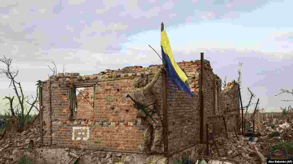 Ukrajinski vojnik postavlja nacionalnu zastavu na vrh uništene kuće u ponovno osvojenom selu Andriyivka u regiji Donjeck 16. septembra. Zauzimanje i&nbsp;Andrijivke i&nbsp;Kliščivke -- koje se nalaze na uzvišenju -- omogućilo bi&nbsp;ukrajinskim trupama da sa sjevera i juga napadnu ukopane ruske snage u Bahmutu. &nbsp;