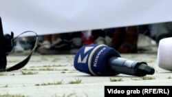 Një mikrofon me logon e televizionit Klan Kosova, në tokë, gjatë një proteste të gazetarëve në Prishtinë, më 31 korrik 2023.