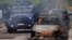 Служители на специалните полицейски сили стоят до горяща кола след сблъсъци между косовската полиция и етнически сръбски протестиращи в петък