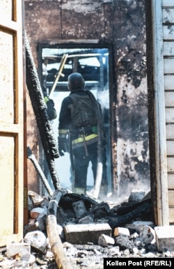 Vatrogasac ulazi u kuću u ruševinama dok tinja vatra pošto je pogođena ruskom kliznom bombom.